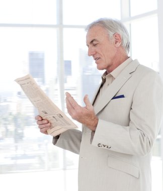 Portrait of a mature manager reading newspaper clipart