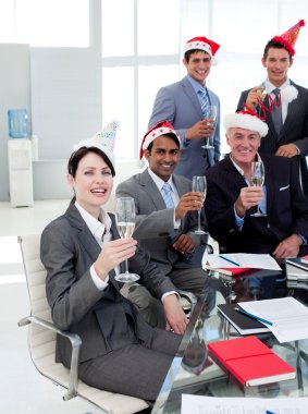 Manager and his team with novelty Christmas hat toasting at a pa clipart