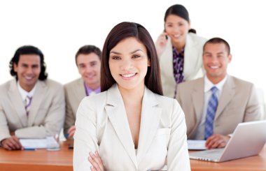 Assertive businesswoman with her team in the background clipart