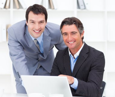 Close-up of two businessmen working at a computer clipart