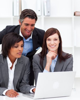 Positive businesswomen and their colleague working at a laptop clipart