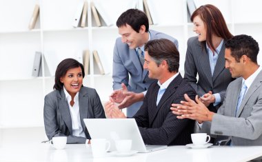 Laughing businesswoman applauded by her team clipart