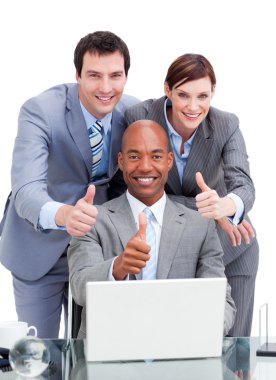 Diverse business co-workers with thums up at a laptop clipart