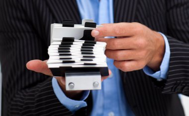 Close-up of a businessman holding a card holder clipart