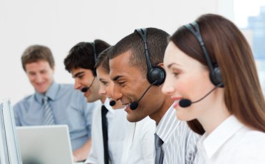 Multi-ethnic customer service agents in a call center clipart