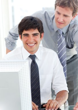 Handsome businessman working at a computer with his manager clipart