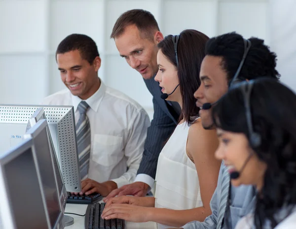 Manager helpen zijn zakelijke team in een callcenter — Stockfoto