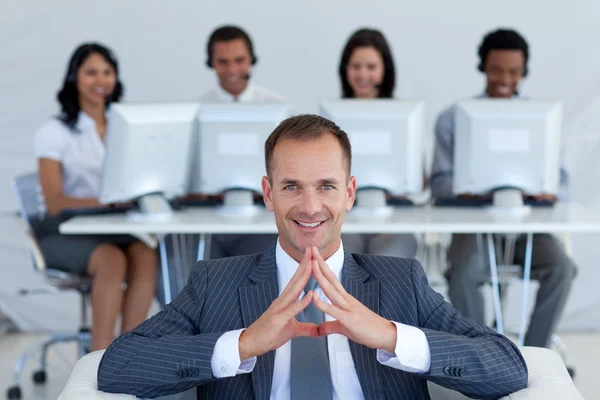 Gerente sorridente no call center na frente de sua equipe — Fotografia de Stock