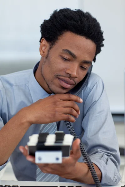 Jonge zakenman op telefoon kijken naar kaarthouder — Stockfoto