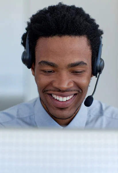 Lachende Afro-Amerikaanse zakenman praten in een callcenter — Stockfoto