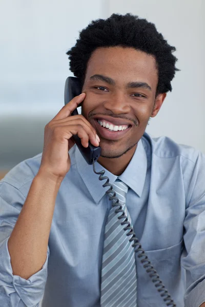 Retrato de un hombre de negocios afroamericano sonriente al teléfono en la oficina — Foto de Stock