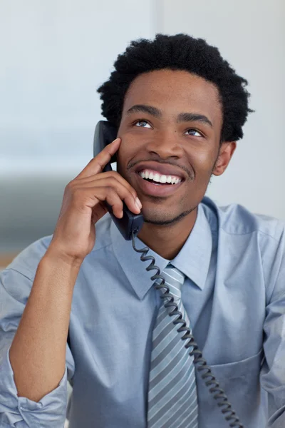 Atractivo hombre de negocios afroamericano sonriente en el teléfono en la oficina — Foto de Stock