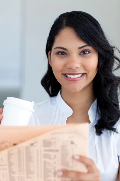 Affärskvinna dricker kaffe och läser en tidning — Stockfoto