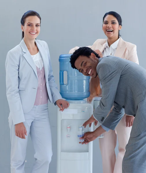 Geschäftsteam trinkt aus einem Wasserkühler — Stockfoto