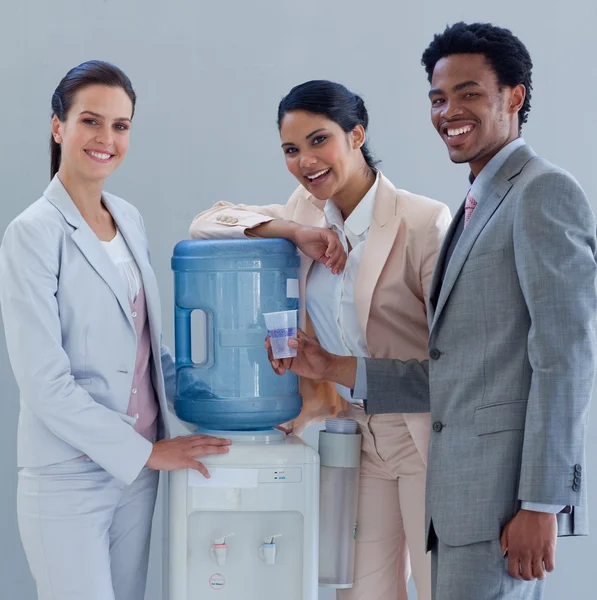 Smiling business with a water cooler in office — Stock Photo, Image
