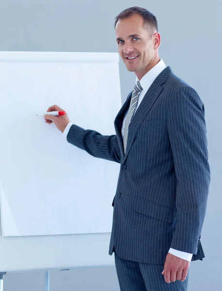 Homem de negócios maduro escrevendo em um quadro branco — Fotografia de Stock