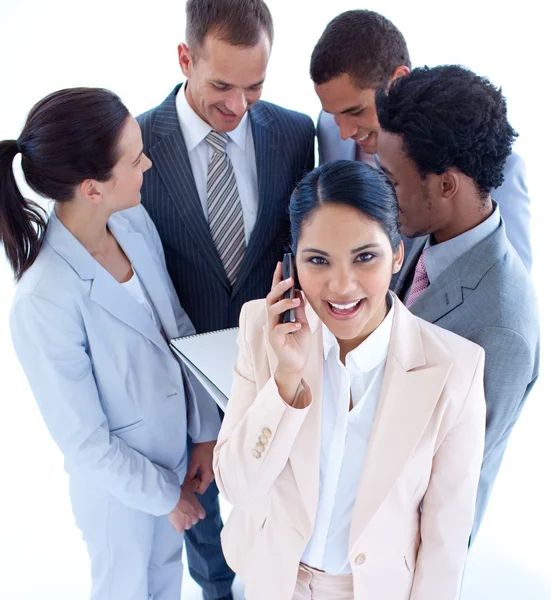 Businesswoman on phone and her team in the background — Stock Photo, Image