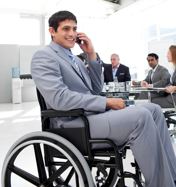 Businessman in a wheelchair on phone during a meeting — Stock Photo, Image