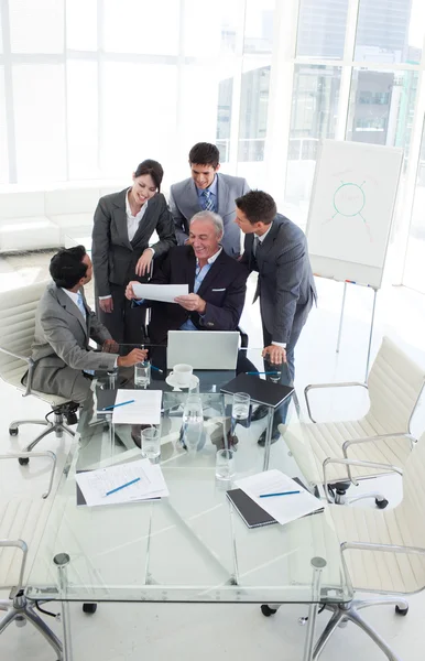 Happy diverse business studying a sales report — Stock Photo, Image