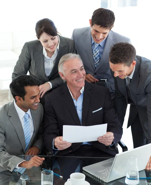 Grupo empresarial multiétnico feliz que estuda um documento — Fotografia de Stock