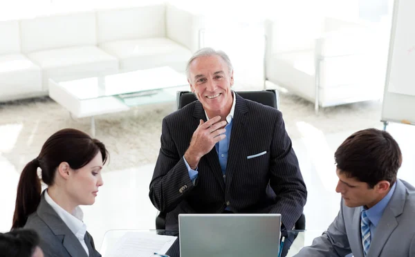Selbstbewusster Manager lächelt bei einem Meeting in die Kamera — Stockfoto