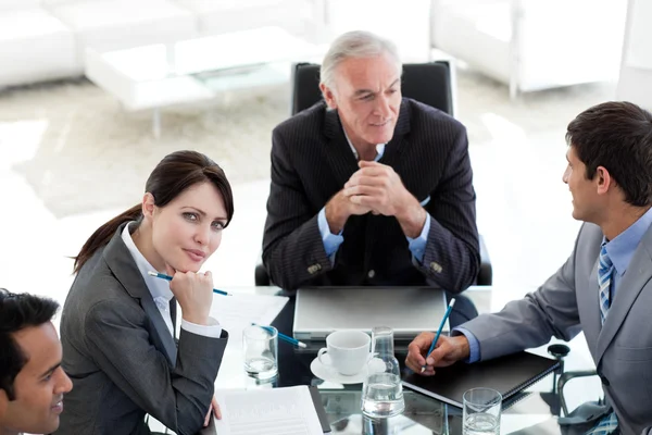 Aantrekkelijke zakenvrouw zitten aan een conferentietafel met haar — Stockfoto
