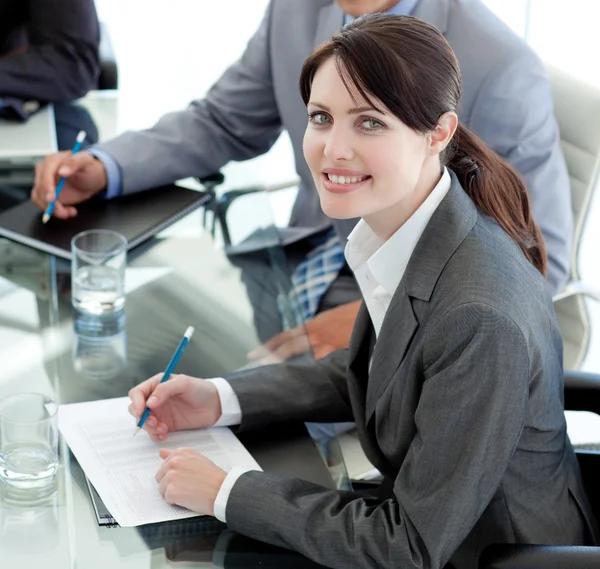 Smiling businesswoman studying a document in a meeting — Stock Photo, Image