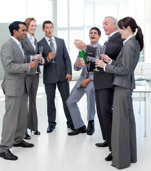 Equipe de negócios de sucesso estourando a rolha em uma garrafa de Champag — Fotografia de Stock