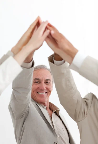 Empresário sorrindo juntando as mãos com sua equipe — Fotografia de Stock
