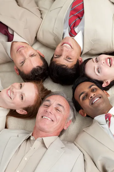 Багатонаціональна бізнес команда лежить в колі — стокове фото