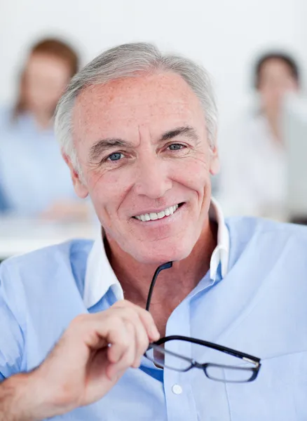 Senior businessman holding glasses — Stock Photo, Image