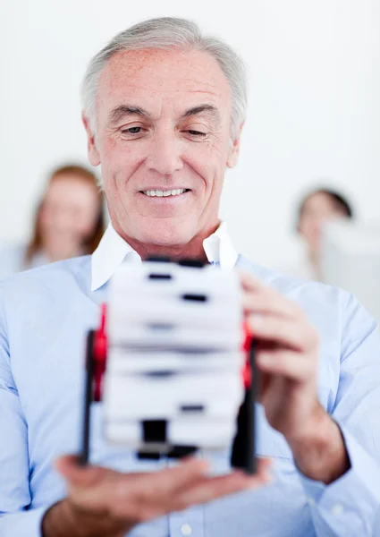 Senior obchodník drží držitele karty business — Stock fotografie