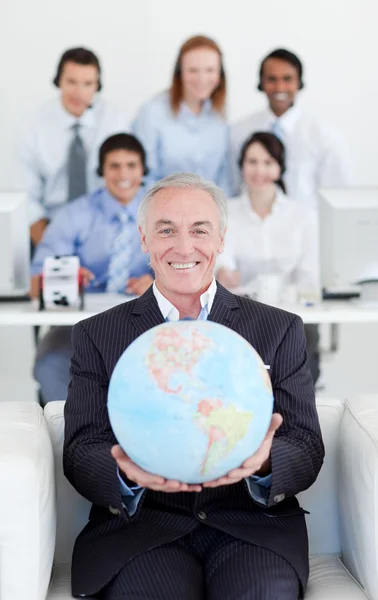 Un hombre de negocios sonriente sosteniendo un globo terrestre — Foto de Stock
