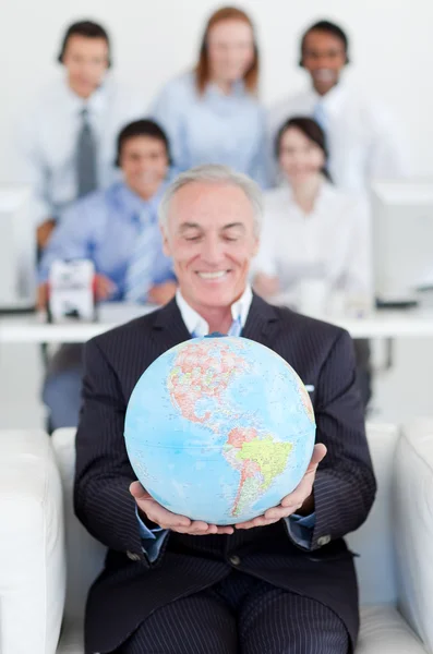 Senior affärsman innehar en terrestrial globe — Stockfoto