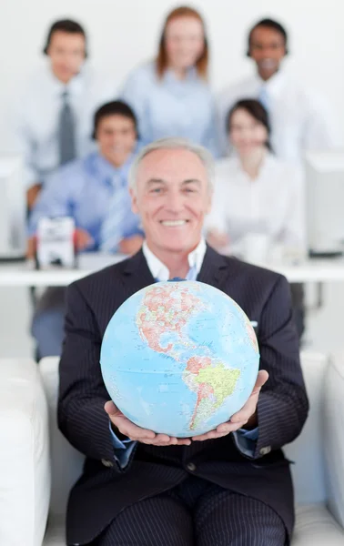 Senior manager innehar en terrestrial globe — Stockfoto