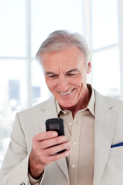 Un uomo d'affari anziano sorridente che manda un messaggio — Foto Stock