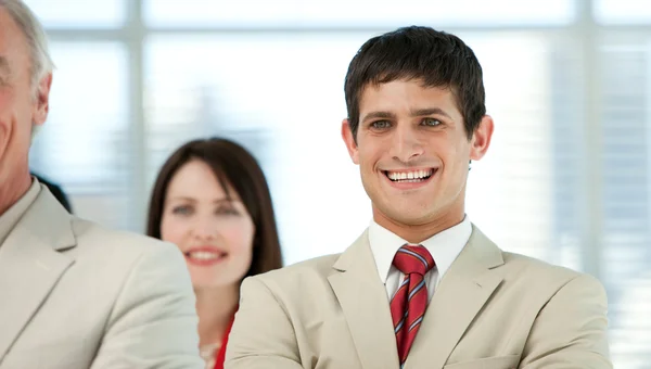 Усміхнений молодий бізнесмен зі своїми колегами — стокове фото
