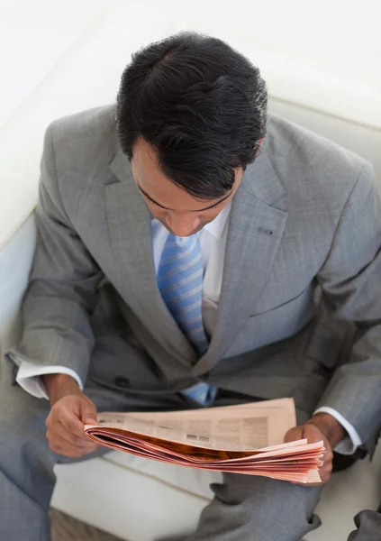 Uomo d'affari etnico che legge un giornale in attesa di un lavoro i — Foto Stock