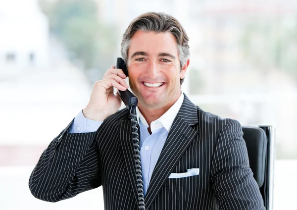 Самоуверенный зрелый бизнесмен разговаривает по телефону — стоковое фото