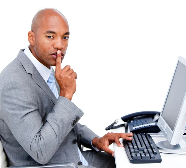 Confident businessman asking for silence sitting at his desk — Stock Photo, Image