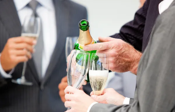 Närbild av en affärsman som serverar champagne — Stockfoto