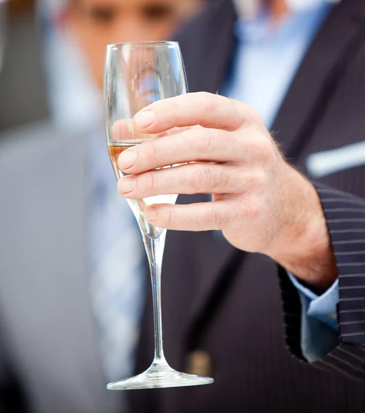 Närbild av en affärsman som håller ett glas champagne — Stockfoto