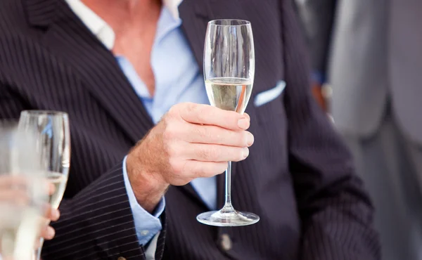 Közeli kép: egy vezető üzletember, aki egy pohár pezsgő — Stock Fotó