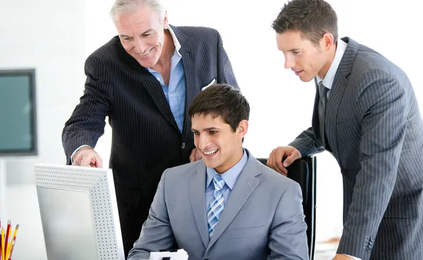 Положительные бизнесмены, работающие за компьютером — стоковое фото