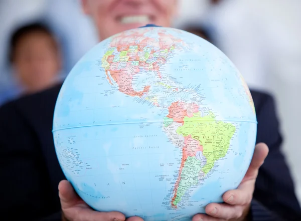 Närbild av en affärsman som innehar en terrestrial globe — Stockfoto