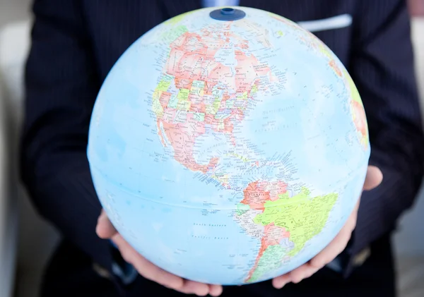 Närbild av en business-person som innehar en terrestrial globe — Stockfoto
