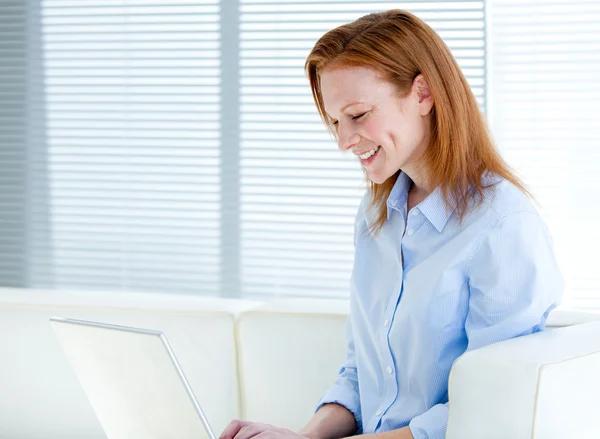 Mulher de negócios feliz trabalhando em um computador portátil — Fotografia de Stock
