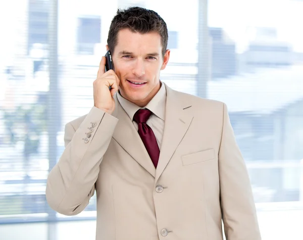 Assertive businessman talking on phone standing — Stock Photo, Image