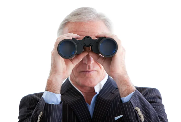 Hombre de negocios serio mirando a través de prismáticos de pie — Foto de Stock