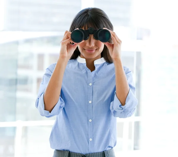 Assertive female executive looking through binoculars — Stock Photo, Image